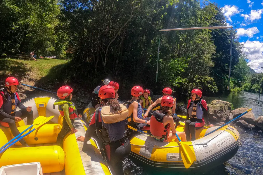 “Grupo relajándose sobre el bote inflable en la actividad de flotada familiar río Liucura.”