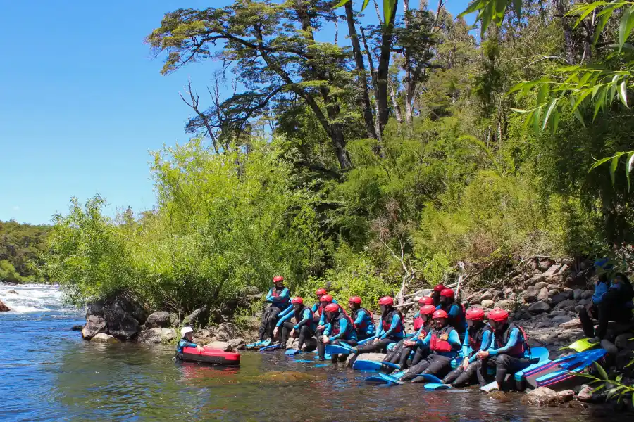 Guía de aventura acompañando a los participantes en el hidrospeed río Trancura bajo