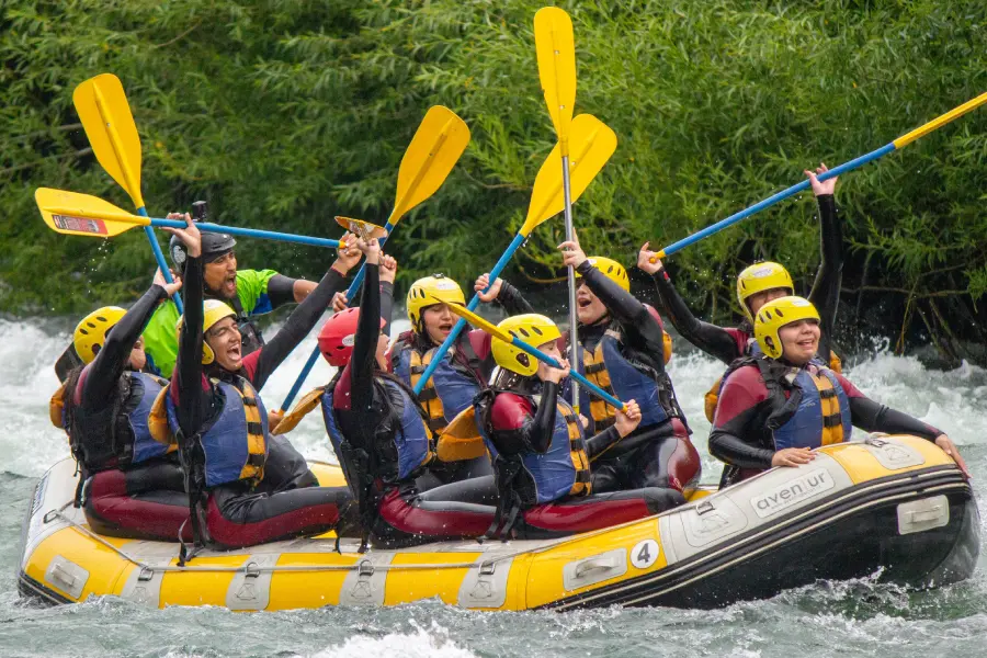“Turistas disfrutando del rafting río Trancura bajo en una aventura segura y divertida.”