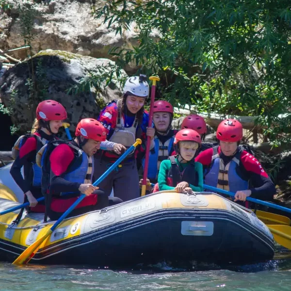 “Participantes viviendo la emoción del rafting río Trancura bajo en aguas cristalinas.”
