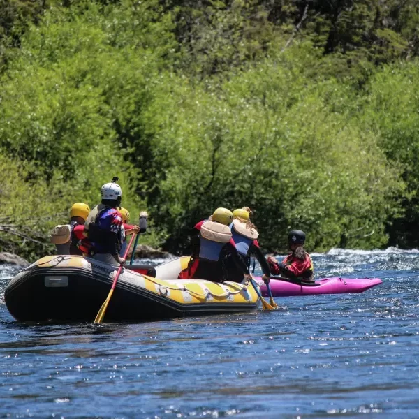 “Experiencia familiar de rafting río Trancura bajo rodeada de naturaleza y montañas.”