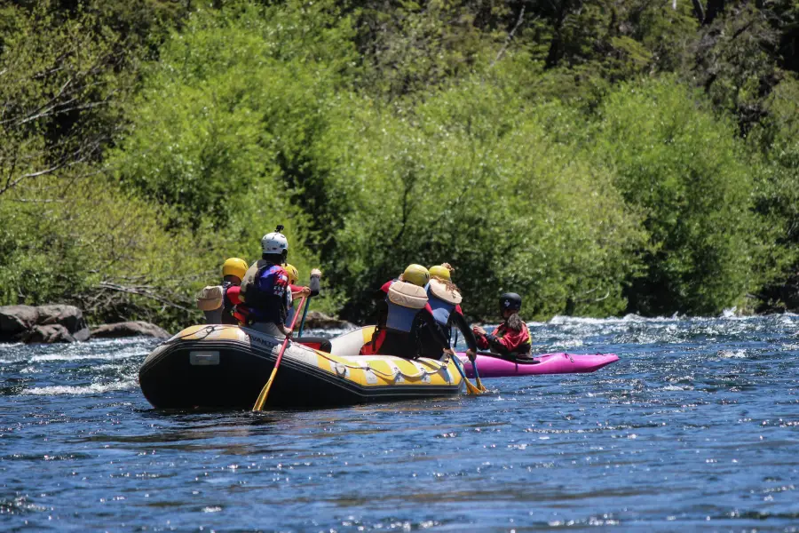 “Experiencia familiar de rafting río Trancura bajo rodeada de naturaleza y montañas.”