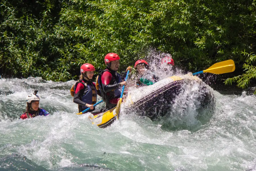 “Bote inflable descendiendo por los rápidos del rafting río Trancura bajo en Pucón.”