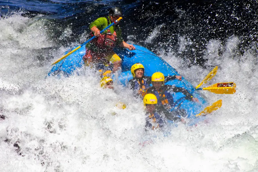 “Aventureros descendiendo los rápidos en la experiencia de rafting río Trancura alto.”