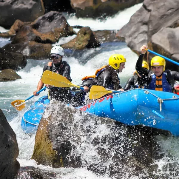 “Equipo de turistas remando juntos en los rápidos del rafting río Trancura alto.”