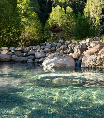 Escápate a las Termas Los Pozones de Huife en Pucón. Disfruta de piscinas naturales de aguas termales rodeadas de un entorno natural único. ¡Relajación y bienestar te esperan!