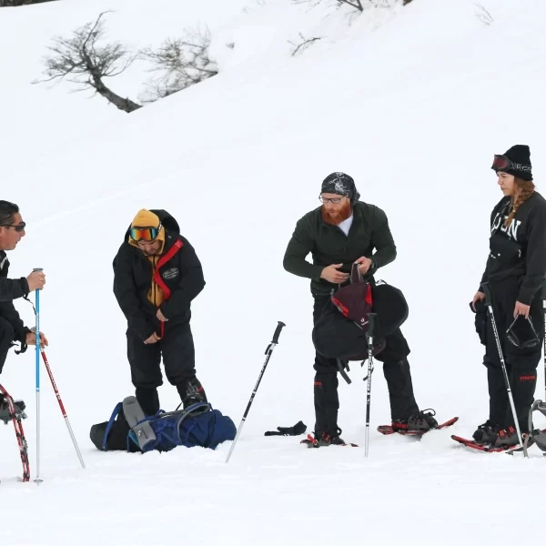 “Participantes ajustando raquetas de nieve en el Trekking con Raquetas a la Base del Volcán Villarrica.”
