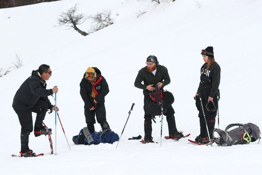 “Participantes ajustando raquetas de nieve en el Trekking con Raquetas a la Base del Volcán Villarrica.”