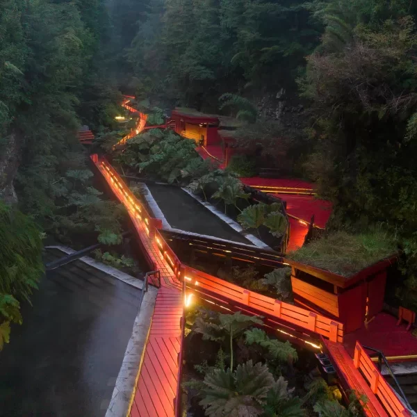 “Ambiente nocturno en las Termas Geométricas con vapor y luces cálidas.”