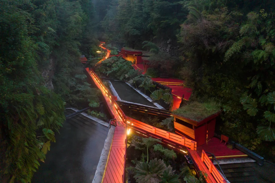 “Ambiente nocturno en las Termas Geométricas con vapor y luces cálidas.”