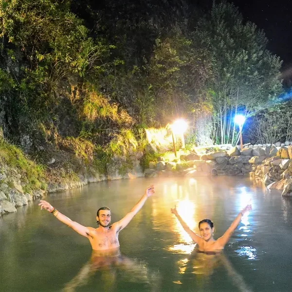 “Ambiente romántico en las Termas Los Pozones de Huife con pareja en piscina nocturna.”
