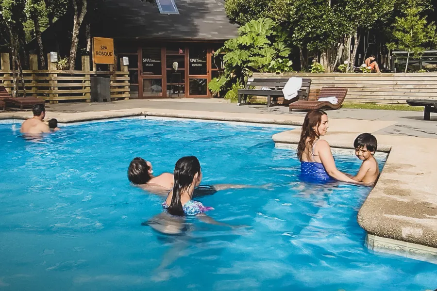“Turistas relajándose en las aguas termales de Termas Pucón Indómito.”