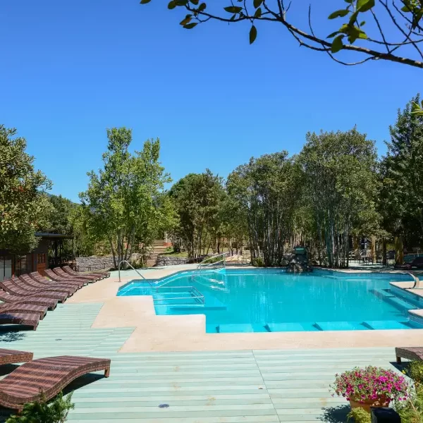 “Zona de descanso y piscinas en Termas Pucón Indómito en plena naturaleza.”