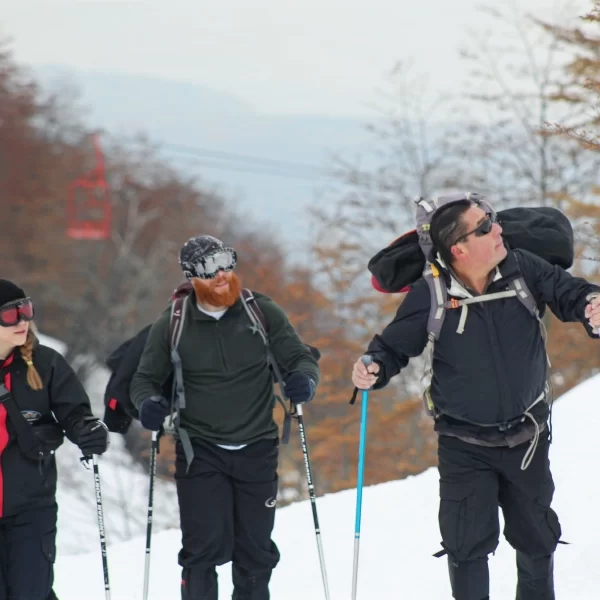 “Grupo realizando Trekking con Raquetas a la Base del Volcán Villarrica sobre nieve.”