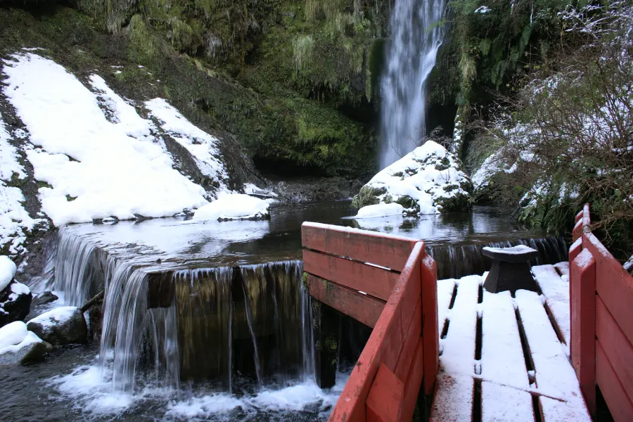 “Escenario de nieve, cascada y termas en Termas Geométricas Invernal.”