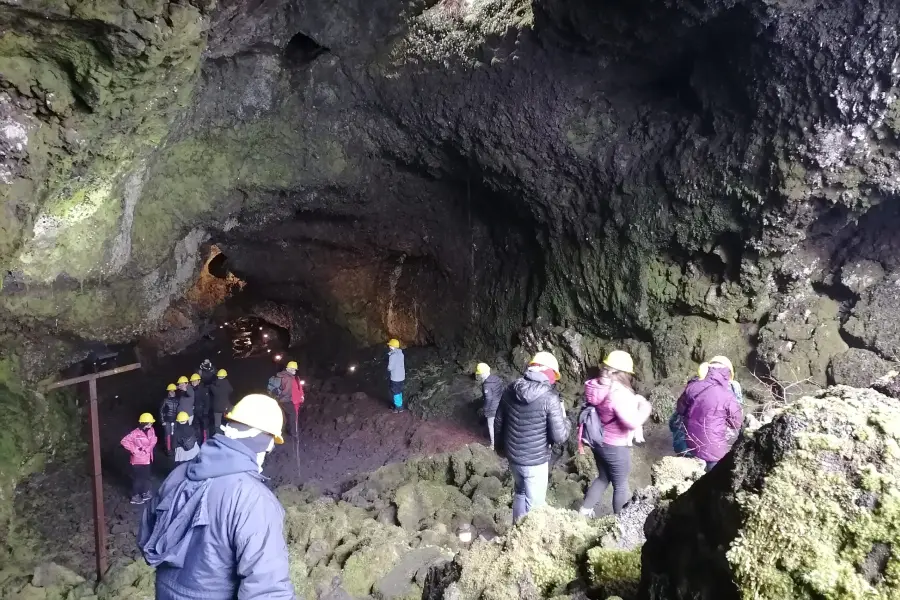 “Visitantes recorriendo una cueva en el Tour Invernal a las Cuevas Volcánicas.”