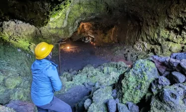 “Visitante ingresando a un túnel de lava en el Tour Invernal a las Cuevas Volcánicas.”