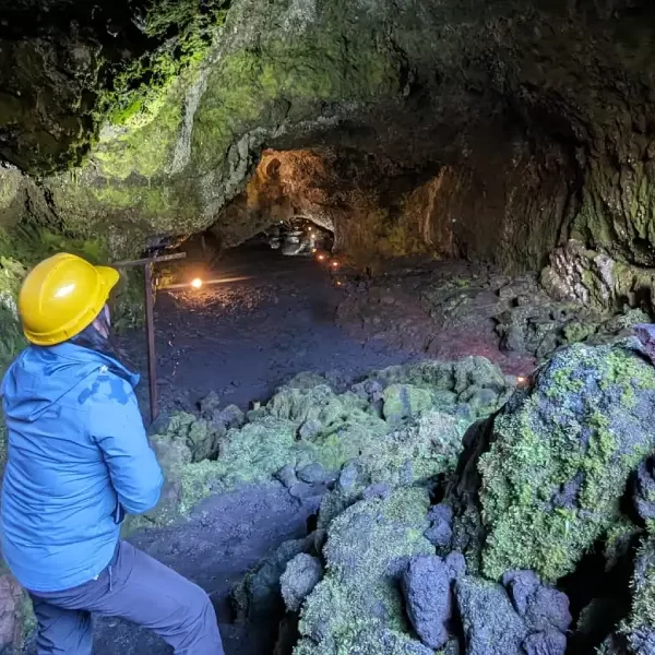 “Visitante ingresando a un túnel de lava en el Tour Invernal a las Cuevas Volcánicas.”