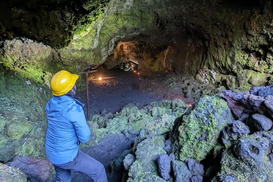 “Visitante ingresando a un túnel de lava en el Tour Invernal a las Cuevas Volcánicas.”