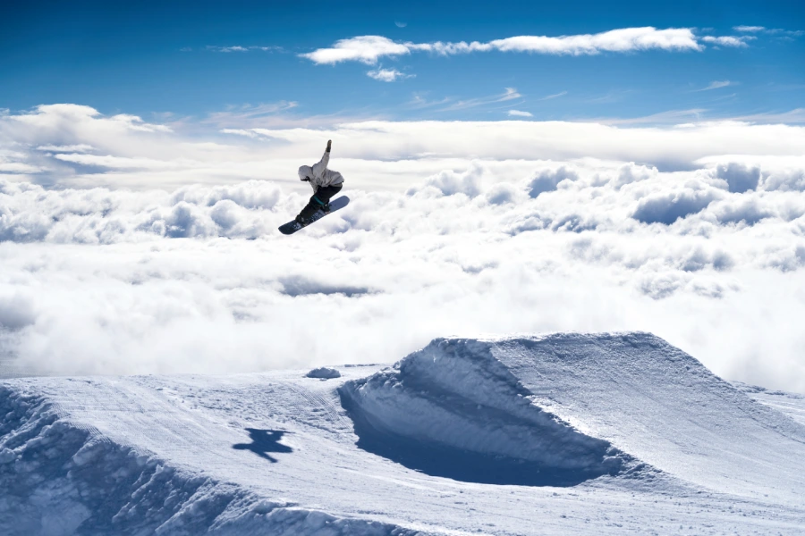 “Turista realizando saltos con equipos de alquiler de ski o snowboard.”