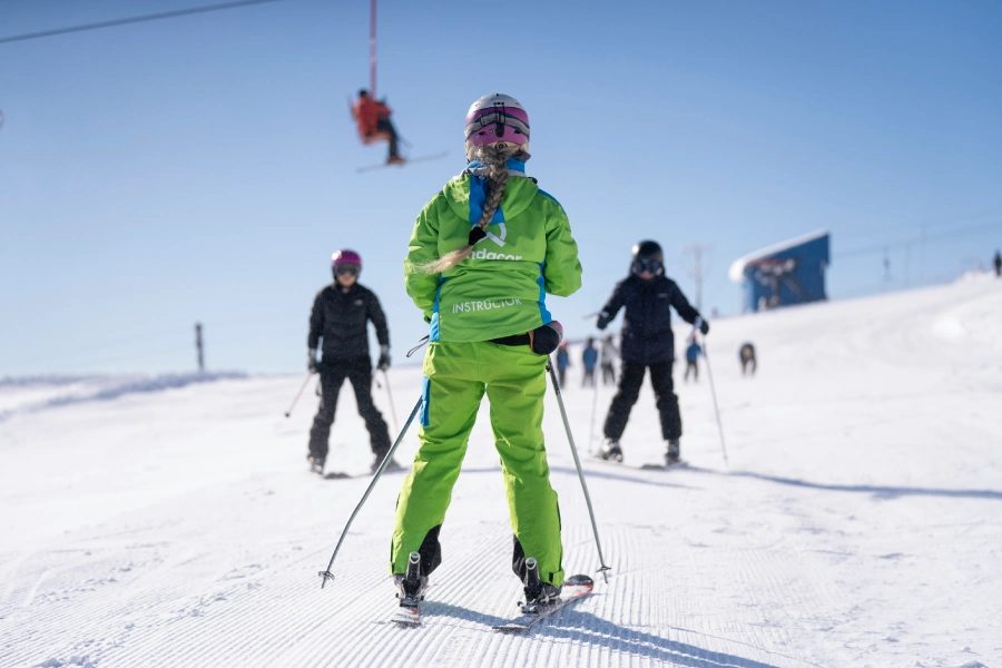 “Instructor guiando clases privadas de ski o snowboard en la nieve.”