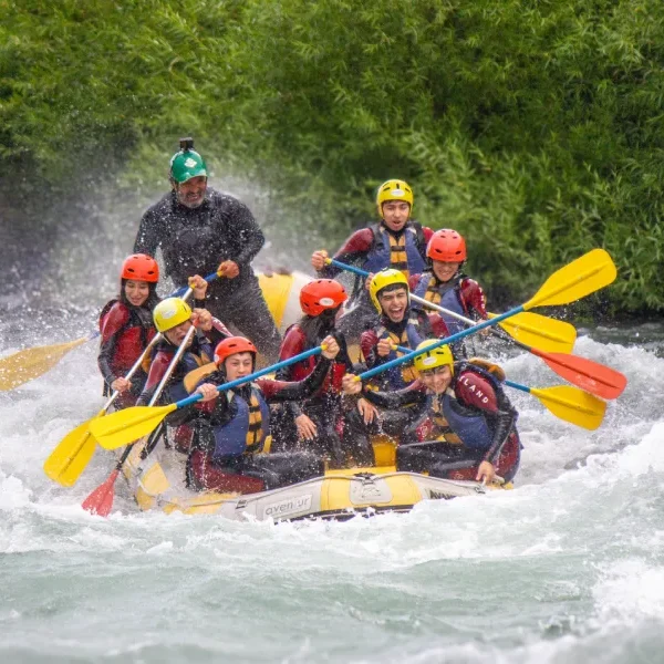 “Turistas disfrutando rafting invernal en aguas rápidas.”
