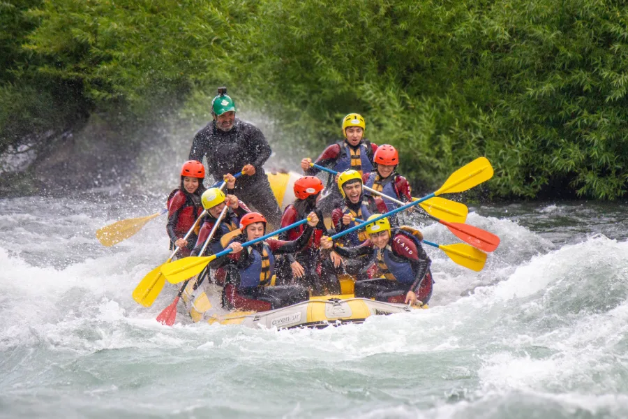“Turistas disfrutando rafting invernal en aguas rápidas.”