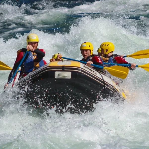 “Turistas enfrentando rápidos fuertes en rafting invernal.”