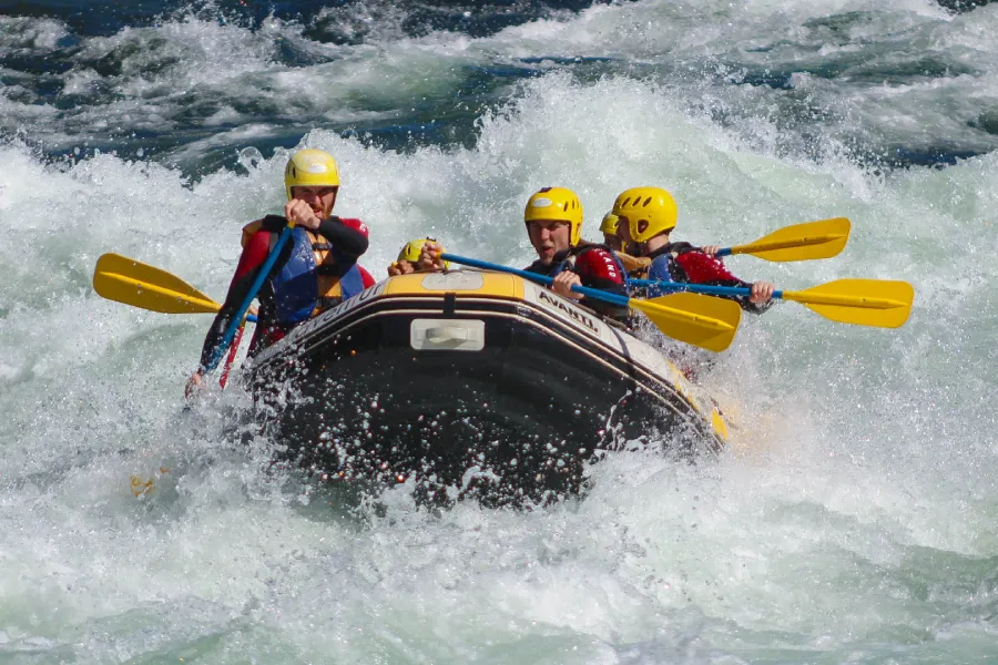 “Turistas enfrentando rápidos fuertes en rafting invernal.”