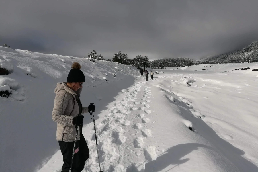 “Trekking con raquetas circuito cuevas volcánicas en paisajes nevados.”